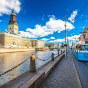 Clock tower and tram passing Gothenburg canal